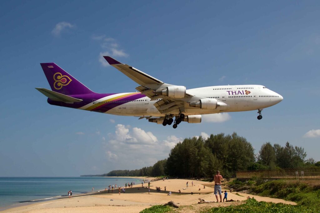 mai khao beach con il passaggio scenofrafico di un aereo della thaiairways